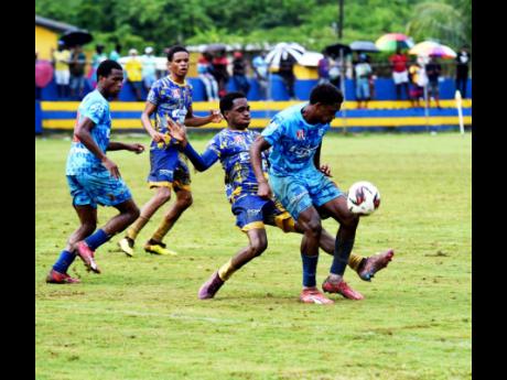 Credit: Ashley Anguin St Elizabeth Technical High School’s (STETHS) Deandre Barnett (second right) tackles McGrath High School’s Farel Tucker (right) during their ISSA/WATA daCosta Cup quarter-final clash at STETHS on Saturday.