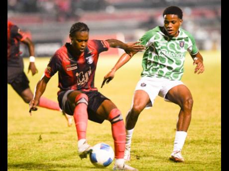 Credit: Ricardo Makyn Arnette Gardens’ Warner Brown (left) comes under pressure from Tivoli Gardens’ Janoi Williams during their Jamaica Premier League football match at Anthony Spaulding Sports Complex last night. Arnett won 2-1.