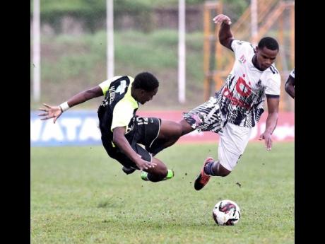 Jabarie Howell (left) from Jamaica College (JC) clash with Raje Ximenes of Kingston College while competing for the ball during their ISSA Manning Cup quarterfinal football match at Stadium East yesterday. JC won 3-0.