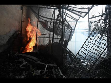 Credit: Rudolph Brown Photos Some of the damage inside the Pearnel Charles Arcade in downtown Kingston after yesterday morning’s fire.