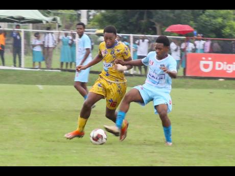 Devor Wynter (right) of Denbigh High challenges Chenon Watson of Clarendon College for the ball during their Ben Francis KO semifinal match at Glenmuir High yesterday. Clarendon College won 1-0