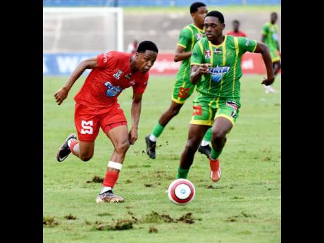 Credit: Ian Allen Photos Orane Watson (left) of Glenmuir High, in a match race with Robert Morris of Ocho Rios High School, during the ISSA WATA Champions Cup KO semi-final football match at the National Stadium on Wednesday. Glenmuir won 5-1.