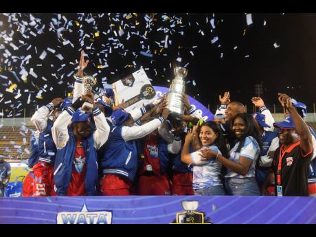 Glenmuir High School's players and officials celebrate their successful defence of the ISSA WATA Champions Cup after defeating Jamaica College 3-1 in the final at the National Stadium on Saturday.
