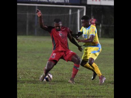 Credit: Antoine Lodge Brian Brown of Montego Bay United (left) and Andre Smith of Waterhouse FC fight for the ball during the Jamaica Premier League football match at Waterhouse Mini-Stadium on Thursday. Waterhouse were beaten 1-0 by Arnett Gardens in their match at Drewsland last night.