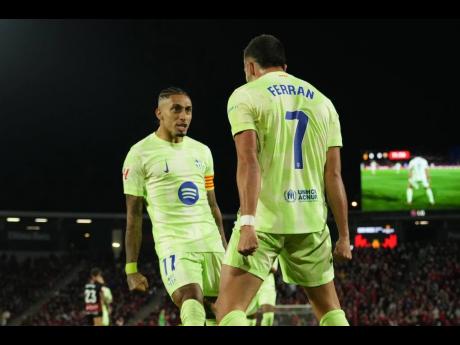 Barcelona’s Ferran Torres (right) celebrates with Raphinha after scoring the opening goal during a Spanish La Liga  match between Mallorca and Barcelona at the Son Moix Stadium in Palma de Mallorca, Spain, yesterday.