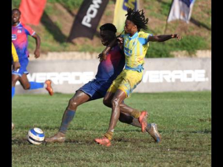 Chantamoi Taylor of Dunbeholden Football Club (left) battles for the ball against Jaheim Brown of Waterhouse Football Club during their Jamaica Premier League football match at Stadium East yesterday. Waterhouse won 3-2.