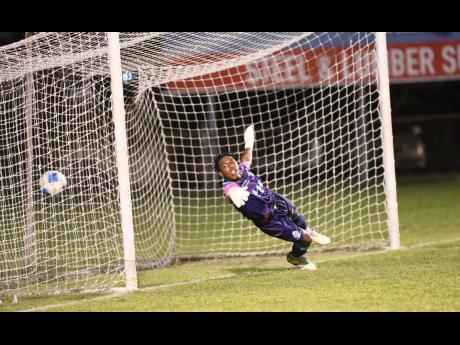 Credit: Matthew McKoy Arnett Gardens FC’s Warner Brown (out of photo) scores a penalty past Harbour View FC’s goalkeeper Demelcio Fer during the Jamaica Premier League football match at Anthony Spaulding Sports Compl;ex last night. Arnett Gardens FC won 2-1.