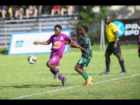 Credit: Matthew McKoy Antowan Mullings(left) of Kingston College tries to keep the ball away from Antwone Simms of Calabar High School during their ISSA Burger King Under-14 football semi-final at Winchester Park yesterday. Kingston College won 7-0.