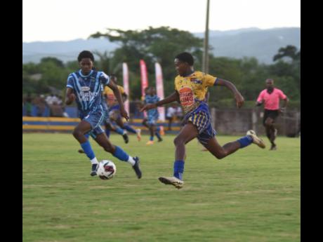 Credit: Ashley Anguin The Manning’s School’s Keandre Ellis (left) and Clarendon College’s Lashaun Harris compete for the ball during their ISSA/Mighty Malt rural under-16 football final at the St Elizabeth Technical High School yesterday. Manning’s won 3-2.