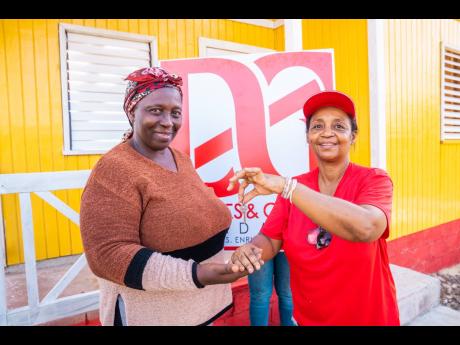 Credit: Contributed Margaret Green (left) beams with pride as she receives the keys to her home from Totlyn Brown-Robb, marking a joyous new beginning.