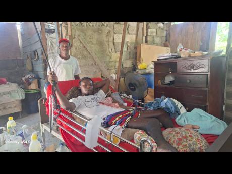 Credit: Almando Smith Photos Winston Scott Sr watches over his son Winston Scott Jr, at their home in Pamphret, St Thomas.