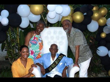 Centenarian Lester Hayle at his 100th birthday celebration in Negril, Westmoreland, on December 24, 2024, with son Carlton, daughter-in-law Marva, and granddaughter Amber.