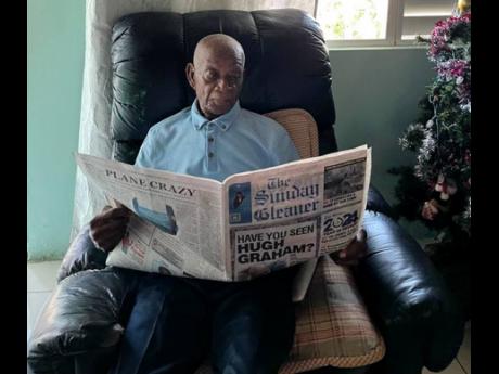 100-year-old Lester Hayle reading The Sunday Gleaner at his home in St James, yesterday.