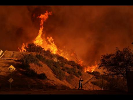 A firefighter battles the Palisades Fire in Mandeville Canyon on Saturday in Los Angeles.