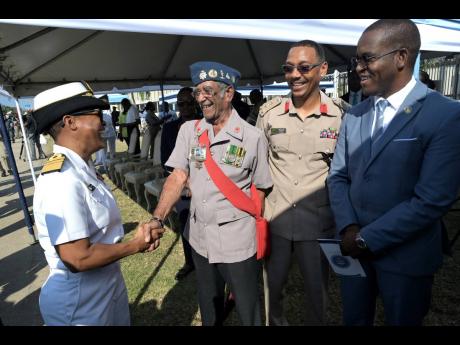 Credit: Rudolph Brown Vice Admiral Antonette Wemyss-Gorman, (left) chief of defence staff of the Jamaica Defence Force (JDF), greets Xevier Williams, (second left), World War ll veteran. Looking on are Mahatma Williams, (second right) foreign liaison officer of the JDF and Dr Kevin Blake, commissioner of the Jamaica Constabulary Force.