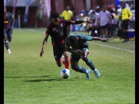Credit: Antoine Lodge Owayne Gordon of Montego Bay United FC (right) stumbles as Jamone Shephard of Arnett Gardens FC closes in during the Jamaica Premier League football match at Anthony Spaulding Sports Complex on Monday. Arnett Gardens won 1-0.