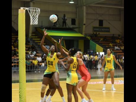 Credit: Antoine Lodge Photos Sunshine Girl Romeldo Aiken-George (left) and Shanice Beckford (second nright) gets into position to grab a rebound during their netball match in the Horizon Netball Series against the England Roses at the National Indoor Sports Centre on November 26.