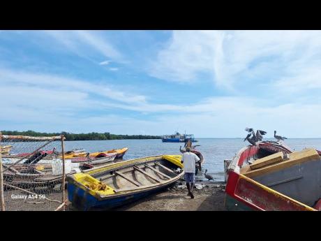 Fishermen tend to their boats in Old Harbour Bay.