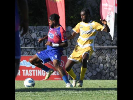 Dean Andre Thomas of Dunbeholden Football Club (left) controls the ball as Stevaughn Johnson of Molynes United Football Club (right) attempts to make a challenge during the Jamaica Premier League football match at the Anthony Spaulding Sports Complex in Kingston yesterday. Dunbeholden won 1-0..