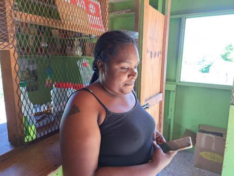 Credit: Christopher Thomas Amoy Maragh wearing a mournful expression as she goes through pictures of her late relative on her phone.