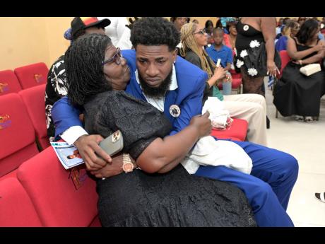 Credit: Rudolph Brown Andrew ‘Bum Bam’ Cox (right) being consoled by his aunt, Sandra Watson, immediately after arriving inside Perry’s Hall of Thanksgiving in St Catherine on Sunday.