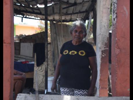 Credit: Photos by Antoine Lodge/Photographer Beatrice Williams stands where her home once stood, surrounded by the ashes of a life now in ruins.