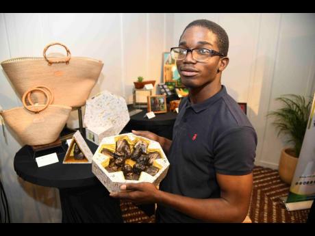 Credit: Antoine Lodge Ajalon Cole, assistant sculptor at Sculpture Elements and Construction Ltd, poses with one of the creations at the inaugural Craft and Coffee event, held on Tuesday at the ROK Hotel in Kingston.