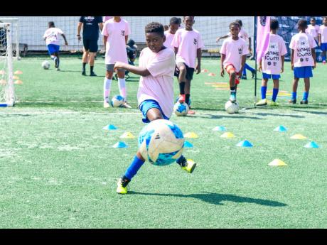 Young local footballer doing shooting drills at the Inter Miami-Royal Caribbean International Youth Clinic at Liberty Park, Kingston,  yesterday.