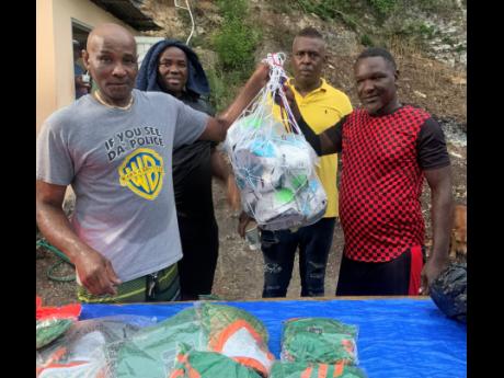 Credit: Adrian Frater Photos Hector Hill (left) handing over footballs to representatives of the Defenders Masters team.