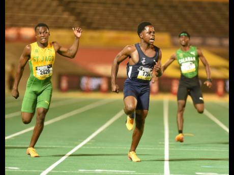 Credit: Ian Allen Jamaica College’s Kai Kelly (centre) celebrates as he crosses the finish line to win the Class Three boys’ 100 metres final in a record 10.60 seconds during the ISSA GraceKennedy Boys and Girls’ Athletics Championships at the National Stadium on Wednesday night. Jevaney Findlay (left) of St. Jago High placed second, while Joshua Ricketts of Calabar High School placed third.