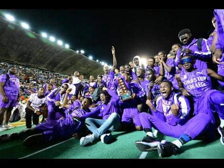Credit: Gladstone Taylor Kingston College athletes sit on the National Stadium track to celebrate winning the Mortimer Geddes Trophy on Saturday night.