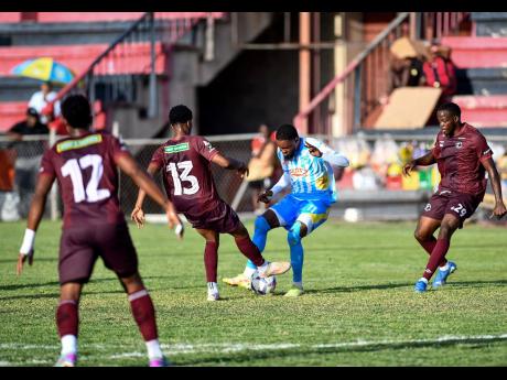 Leonardo Jibbison of Waterhouse FC (second right) is surrounded by Chapelton Maroons players Deandre Cunningham (right), Dunsting Cohen and Andrew Vanzie(left) during the Jamaica Premier League football match at Anthony Spaulding Sports Complex yesterday. The game ended 1-1.