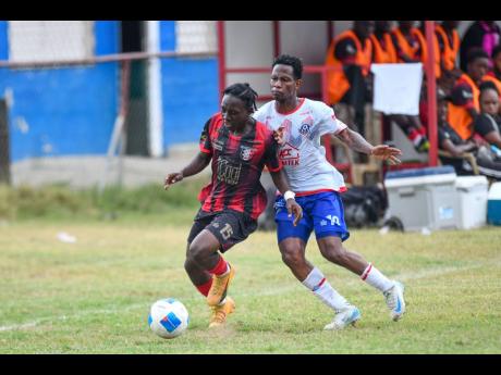 Credit: Matthew McKoy Tarique Jones (left) of Arnett Gardens tries to keep the ball away from Cardel Benbow of Portmore United during their Jamaica Premier League match at Ferdi Neita Park, Portmore yesterday.