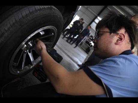 Credit: Antoine Lodge Mechanic Jong Zhangcanqiang handles a repair job at the in-demand WH Car Services.