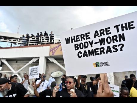 Credit: Rudolph Brown Police keep a watchful eye on protesters yesterday.