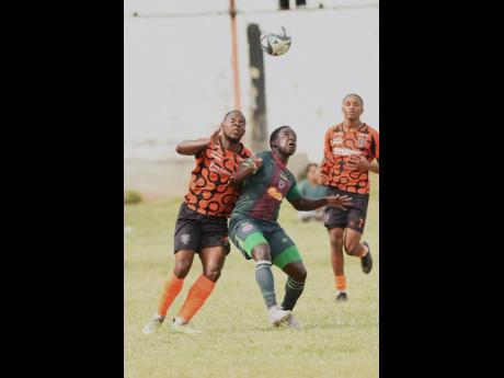 Shaquille Jones (left) of Tivoli Gardens FC and Johan Weatherly (centre) of Montego Bay United compete for the ball during their Jamaica Premier League football match at the Edward Seaga Sports Complex yesterday. Tivoli Gardens FC won 2-1.