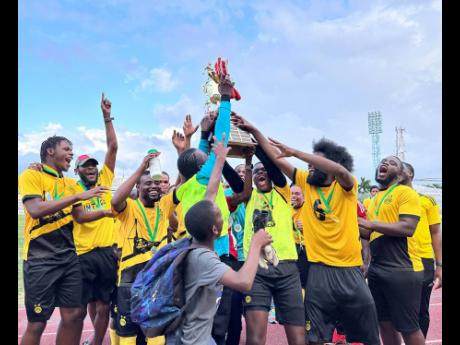 Spanish Town Police FC celebrate by lifting the 2025 Jamaica Football Championships (Tier II) trophy during the post-match presentation ceremony at Drax Hall Sports Complex on Saturday. Spanish Town Police FC defeated Treasure Beach FC 2-0.