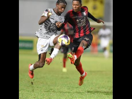 Credit: Ian Allen Jalmaro Calvin (left) of Cavalier SC and Philando Wing of Arnett Gardens compete for the ball during their Jamaica Premier League football semi-final game at Sabina Park on Sunday night. Calvin scored as Cavalier won 1-0.