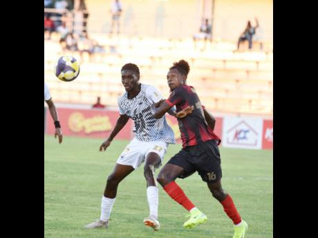 Cavalier FC’s Jerome McLeary (left) tussles with Arnett Gardens FC’s Ricardo Thomas for the ball during their Jamaica Premier League first-leg semi-final match at the Montego Bay Sports Complex in Montego Bay on Thursday, May 15.
