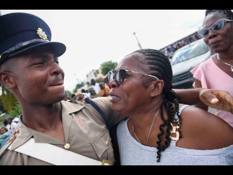 Ockeem Clarke tries his best to hold in the tears of joy while being embraced by his aunt, Mitzie Gayle, at the passing-out parade for Jamaica National Service Corps Intake 2024/01 at Up Park Camp last Thursday. 
