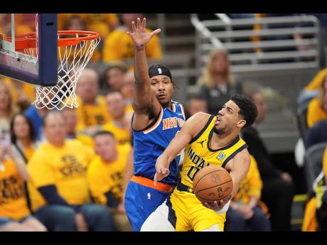 Indiana Pacers guard Tyrese Haliburton (0) shoots the ball past New York Knicks guard Miles McBride (left), during the second half of Game 4 of the Eastern Conference finals of the NBA basketball playoffs in Indianapolis, on Tuesday, May 27.