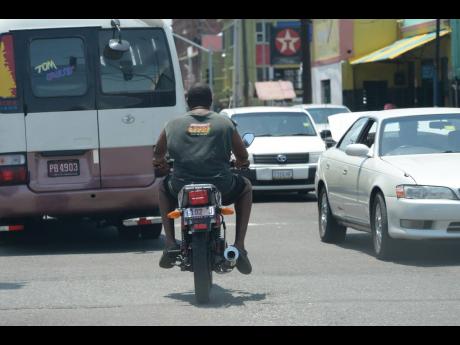 File photo shows motorcyclist without a helmet, operating the vehicle wearing shorts and slippers.