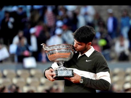 Spain’s Carlos Alcaraz celebrates with the trophy after winning the final match of the French Tennis Open against Italy’s Jannik Sinner at the Roland-Garros stadium in Paris yesterday.