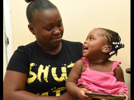 Credit: Ian Allen Azaria reacts with glee to mom Anneil Richards as she hears for the first time after being fitted with the hearing aid.