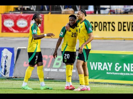 Credit: Matthew McKoy Jamaica’s Jonathon Russell (right) celebrates scoring with teammates Renaldo Cephas (centre) and Amari’i Bell during the Concacaf World Cup Qualifying football match against Guatemala at the National Stadium in Kingston last night. Jamaica won 3-0.