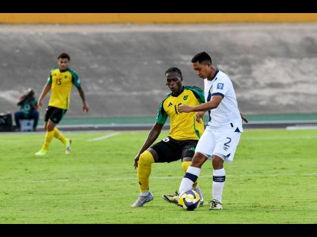 Jamaica’s two-goal hero Warner Brown positions himself to challenge Guatemala’s Jose Ardon for the ball during their Concacaf World Cup Qualifying football match at the National Stadium in Kingston on Tuesday. Jamaica won 3-0.