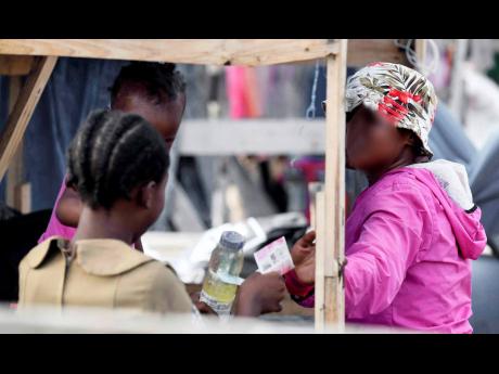Credit: Antoine Lodge This child makes a sale to a woman in downtown Kingston.