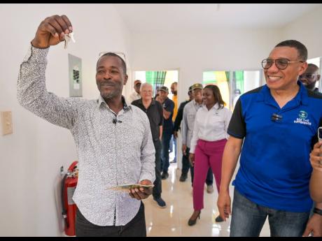 Prime Minister Dr Andrew Holness (right) shares a joyful moment with Patrick Sawyers, the newest recipient of a two-bedroom home under the Government’s New Social Housing Programme.