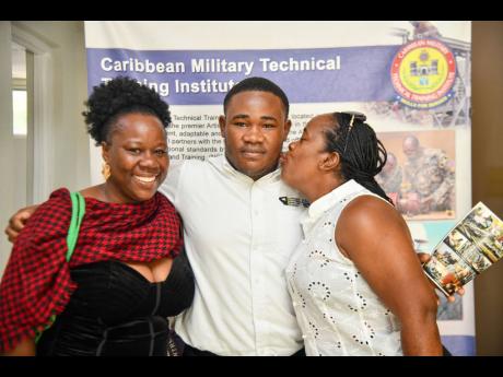 Armani Palmer is flanked by aunt Sydonne Tugwell (left) and mother Debra Tugwell at last Friday’s graduation ceremony for the Jamaica National Service Corps’ (JNSC) Skills Track for Workforce Development programme held at Up Park Camp in Kingston.