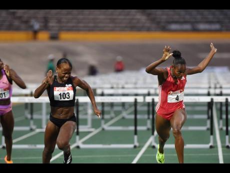 Credit: Ian Allen Megan Tapper winning the women’s 100 metres hurdles final ahead of race favourite Ackera Nugent (right), at the Puma Jamaica Athletics Administrative Association National Junior and Senior Athletic Championships at the National Stadium yesterday.